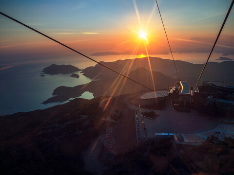 Top view on islands around the Oludeniz and Fethiye resorts in Mugla province, Turkey. Panoramic view from the Babadag mountain on sea sunset at the first funicular station with sun beams.