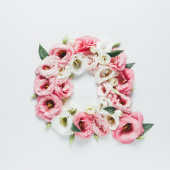 Obraz na płótnie Canvas Letter Q made with flower and leaves on bright white background. Floral mother's day alphabet concept. Spring blossom, valentine or romantic font collection. Flat lay, top view.