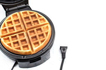 freshly made waffle in an open waffle iron