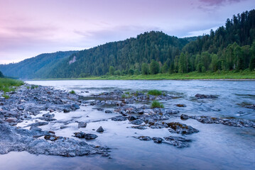 Landscapes of Siberia. Evening landscape at sunset. Mountains, forest, river and water at long exposure. Kemerovo region. Russia