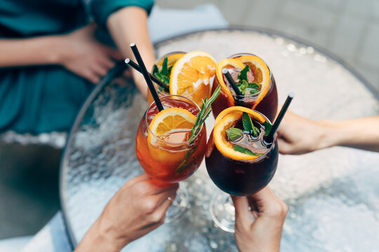 Overhead view of group of friends toasting with summer cocktails.  - Powered by Adobe