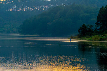 The unknown men row the boat in Tuyen lam lake