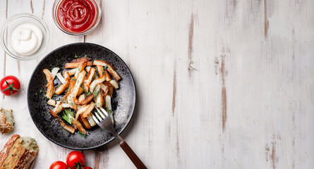 Baked potatoes on a white wooden background. With mayonnaise, ketchup, tomatoes. Banner, place for text.