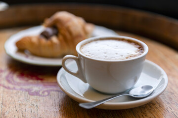 Italy. Scauri. A cup of cappuccino coffee and a croissant in a cafe.
