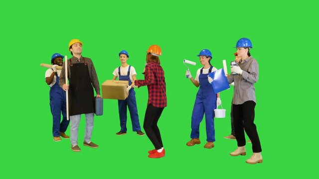 Group of multiethnic construction workers dancing on a Green Screen, Chroma Key.