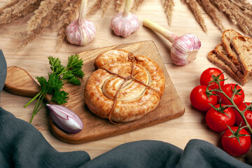 Still life with homemade sausage and vegetables on a wooden table