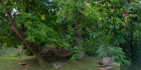 Edelkastanien (Castanea sativa) auch Esskastanie im Garten mit Schaukeln und Badeteich, Italien, Europa,  Panorama