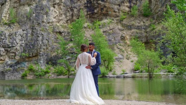 loving newlyweds on the shore of a mountain lake. wedding photo shoot in nature