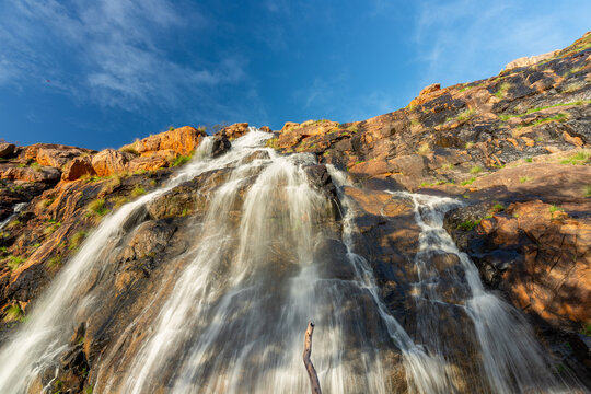 Low angle of a waterfall from a cliff