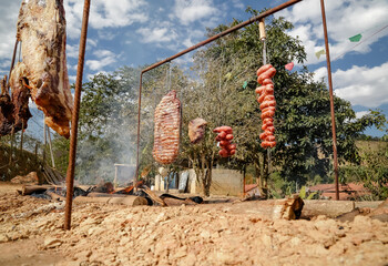 Fototapeta na wymiar Carne assada na fogueira com lenhas estilo gaúcho. 