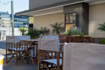 Closeup shot of wooden tables and chairs with cover outside on a sunny day