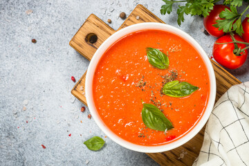 Tomato soup with basil. Summer cold vegan dish. Top view at white background.