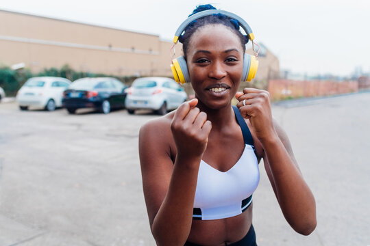 Italy, Milan, Woman in sports clothing and headphones exercising in city