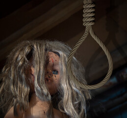 A doll's face and a rope for hanging. A symbol of a defenseless childhood.