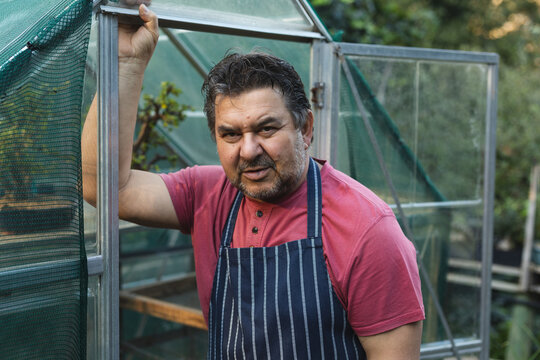 Portrait of caucasian male gardener looking at camera at garden centre - Powered by Adobe