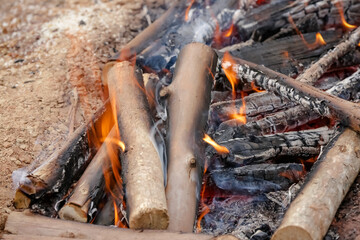 Fogo crepitando no chão, a brasa perfeita para assar carnes, espalhando um aroma irresistível pelo ar.