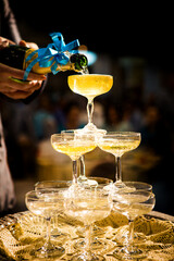 Bride and groom pouring champagne into the glass.