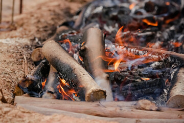 Fogo crepitando no chão, a brasa perfeita para assar carnes, espalhando um aroma irresistível pelo ar.