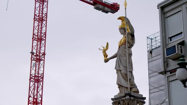 Pallas Athene statue in front of Austrian parliament with construction crane