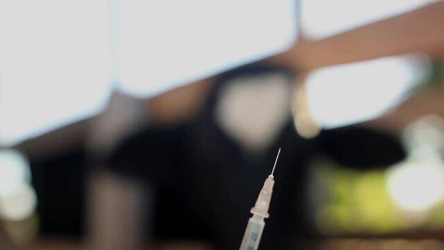 A veterinarian or farmer fills a syringe with vaccine, hormones or medication to inject into a cow 