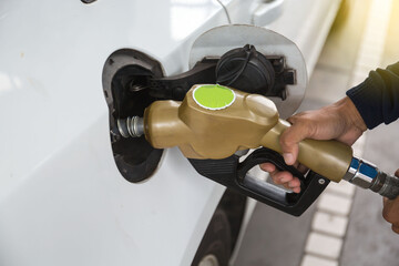 Man pumping gasoline fuel in car at gas station-transportation ,price and ownership oil concept.