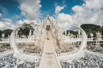 Woman tourist walkng in Wat Rong Khun, known as the White Temple.