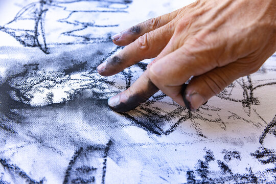 Close up of artists hand painting with graphite crayon - Powered by Adobe