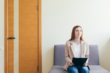 Woman worried in the waiting room corridor, fills out questionnaire tests