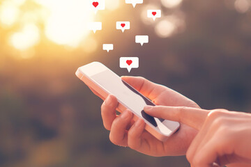 Close up woman hand hold using smart phone with heart icon at outdoor park street background. Copy space of technology business and travel holiday concept.