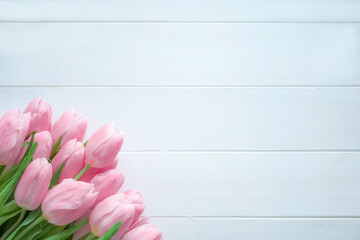 Fototapeta premium Beautiful bouquet of pink tulips on white wooden background with copy space for greeting message.