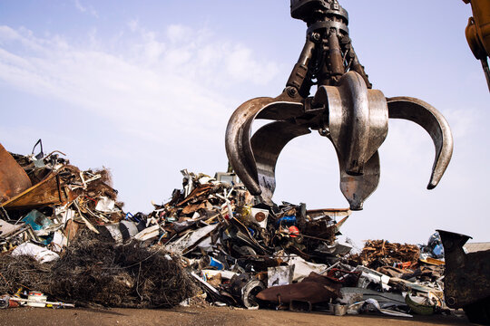 Industrial scrap metal recycling and crane lifting parts in junk yard. - Powered by Adobe