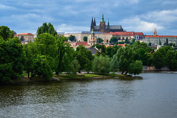 Obraz premium Summer panorama of Prague castle on hill over Vltava river.