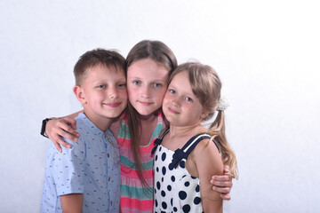 Children portrait, two girls and a boy on a white background in the studio