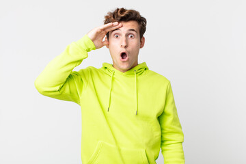 young handsome man looking happy, astonished and surprised, smiling and realizing amazing and...