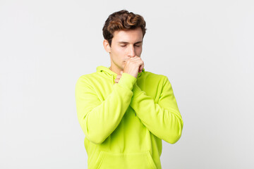 young handsome man feeling ill with a sore throat and flu symptoms, coughing with mouth covered