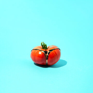 Red tomato painted on the back in panties. Summer scene. Aesthetics on a blue background.