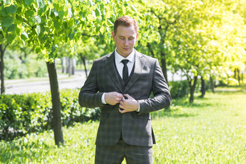 Portrait of a redhead male businessman who is correct jacket on nature