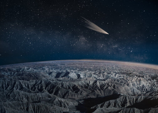 Comet passing over desert badlands, California, USA
