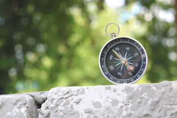 Classic navigation compass on natural background as symbol of tourism with compass, travel with compass and outdoor activities with compass