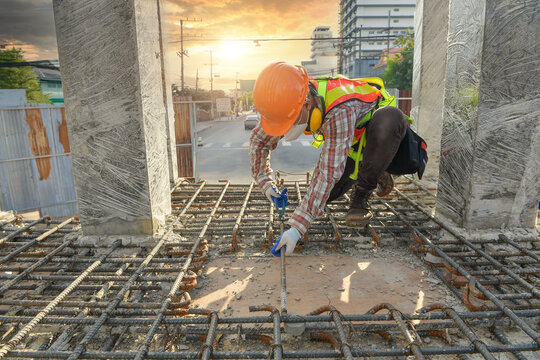 Construction Worker on a building site checking the foundations, Thailand