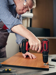 A carpenter makes furniture in a workshop.