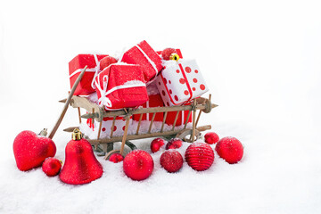 An old wooden cart full of christmas gifts in the snow