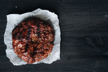Cooked ground beef meat steak cutlets on black table for background.