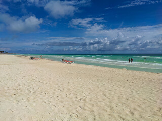 Cayo Coco, Cuba, 16 may 2021: Sandy beach of the hotel Tryp Cayo Coco with sun loungers and tall palm trees. People relax and sunbathe near the ocean on sun loungers.