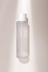 Mock up bottle of essence toner with no label in trendy natural light. Face skin care cosmetics, moisturizer, copy space - obrazy, fototapety, plakaty