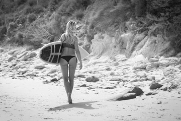 Joven surfista caminando con su tabla de surf por la Playa de Tarifa en Cádiz, Andalucía, España