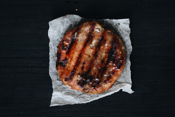 Cooked ground pork meat steak cutlets on black table for background.