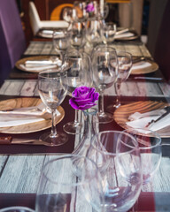 Restaurant table without people due to a pandemic crisis, with a purple flower