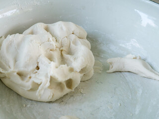 Kid molding white dough with happy face. Asian cute child boy cooking Thai dessert. Concept of family activity, learning cooking, happy moment.