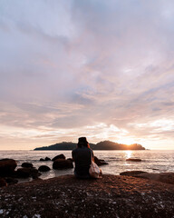 Man chilling by the beach at sunset